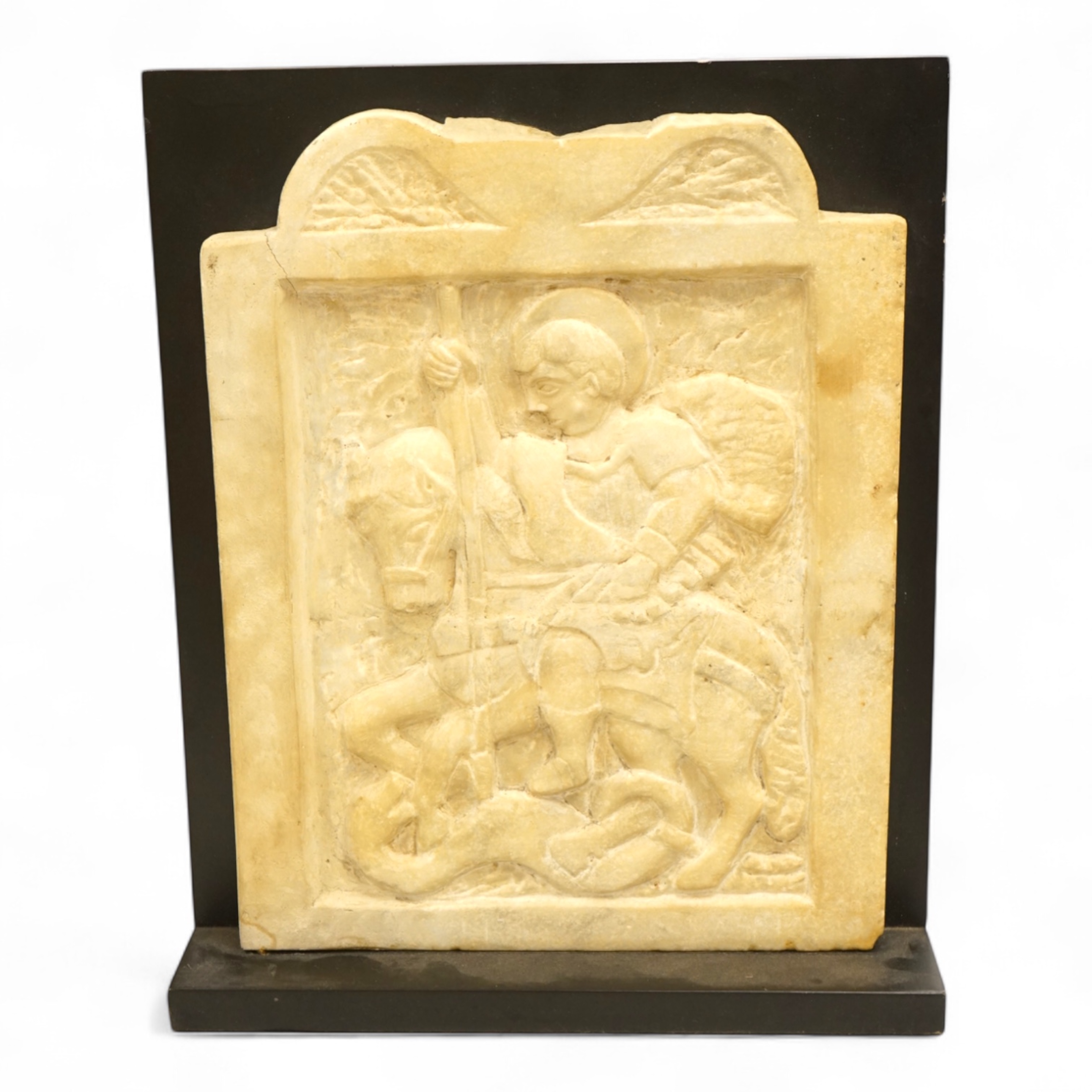 A 19th century carved white marble panel depicting Saint George and the dragon, on stand, 37cm